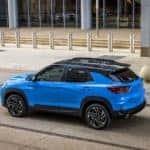 Rear 7/8 view of 2024 Chevrolet Trailblazer RS in Fountain Blue parked in front of a building. Preproduction model shown. Actual production model may vary. Available in fall 2023.