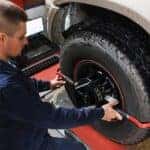A mechanic performing Maserati service tire alignment