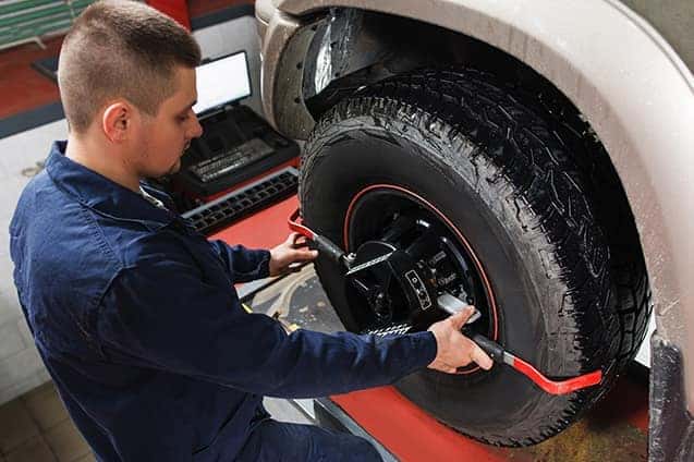 A mechanic performing Maserati service tire alignment