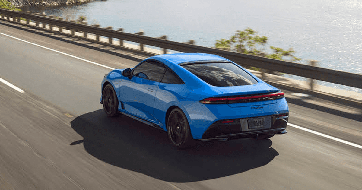 A 2026 Honda Prelude rear view driving on the road next to a lake