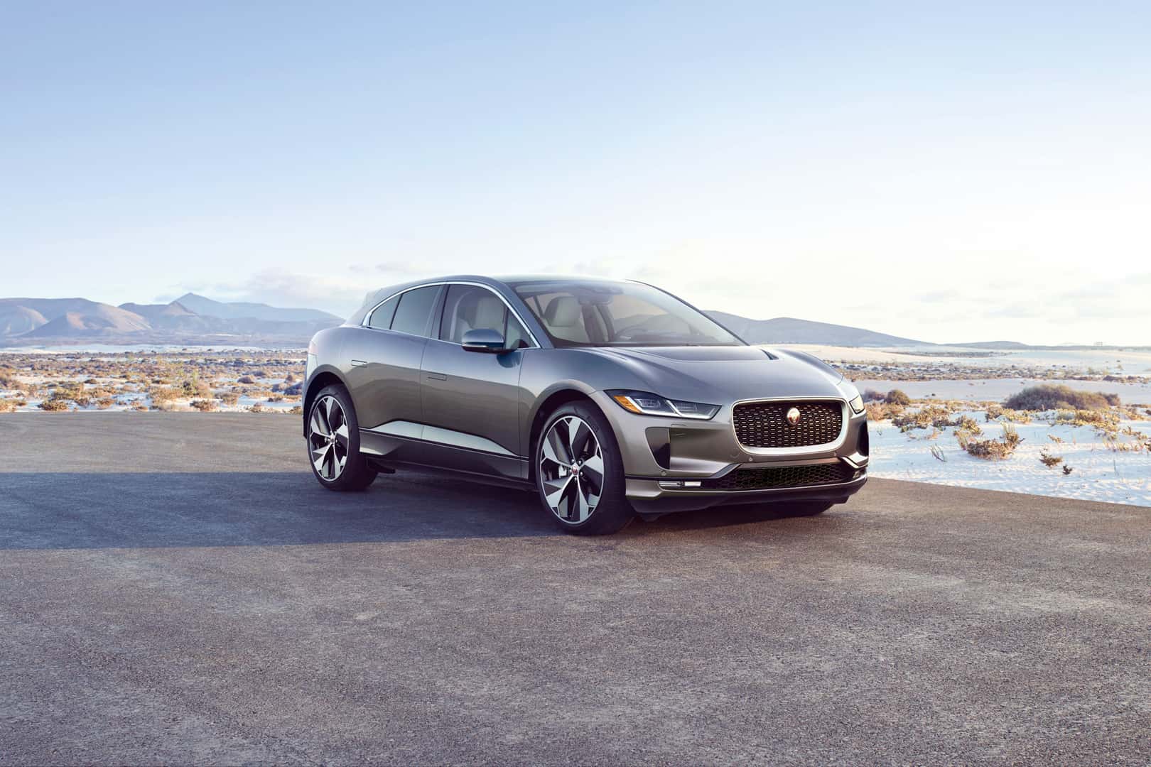 Jaguar I-PACE parked in a snowy desert landscape with mountains in the background