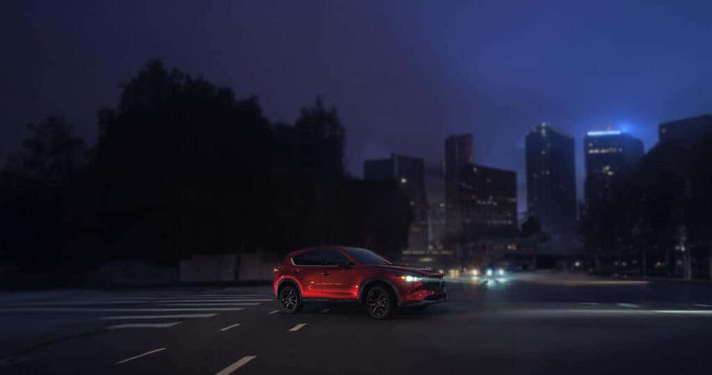 2025-mazda-cx-5-driving-through-a-city-at-night