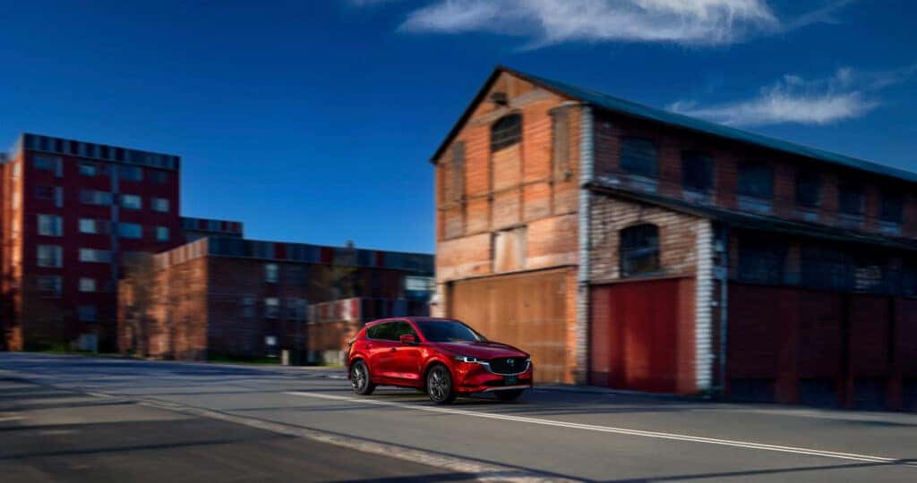 2025-mazda-cx-5-driving-through-an-old-industrial-portion-of-a-town-with-brick-buildings