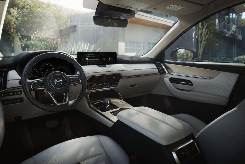 2025-Mazda-CX-90-front-seats-with-driver-console-in-sight-and-house-in-the-background