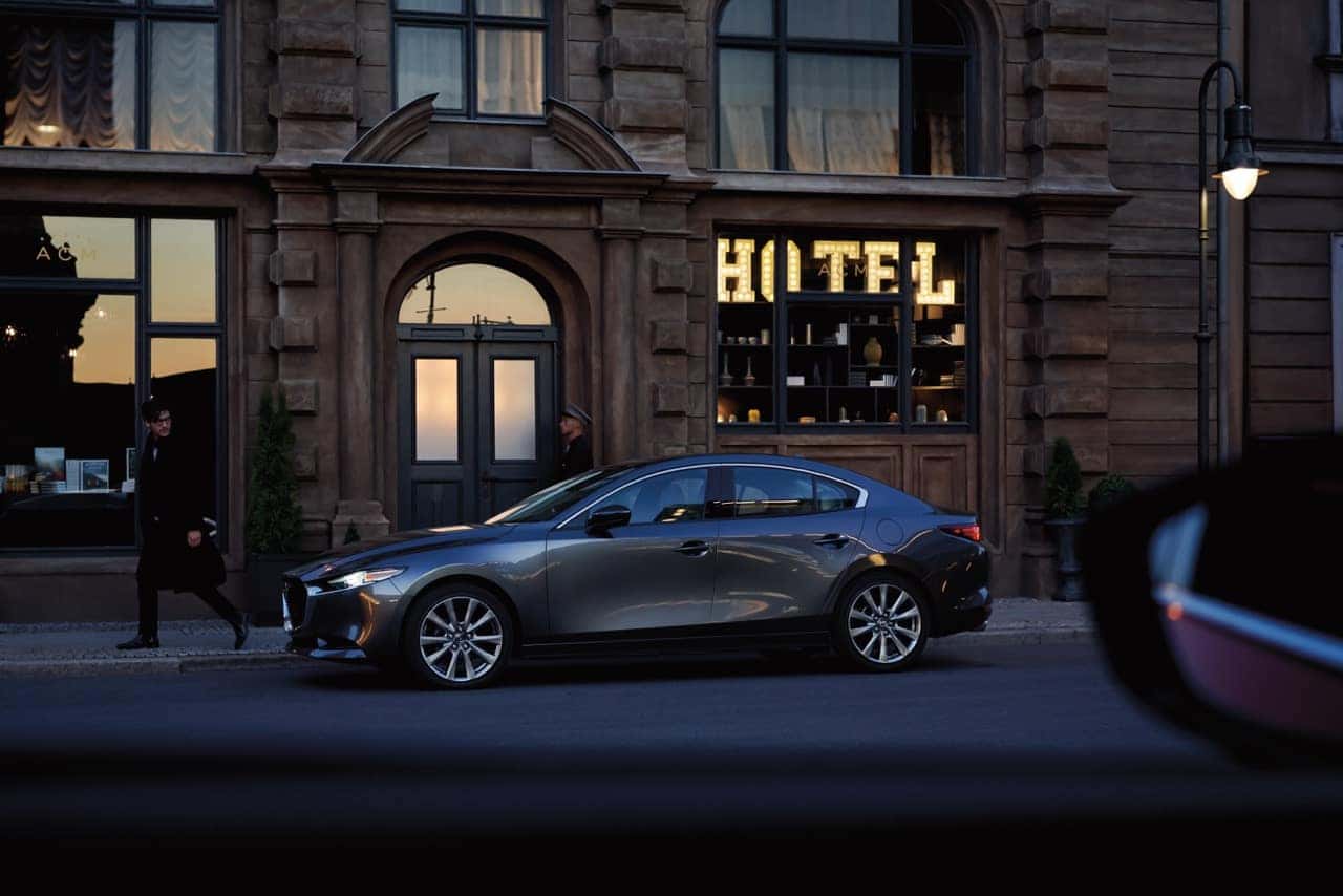 2026 Mazda3 Sedan Body Style parked in front of shops downtown