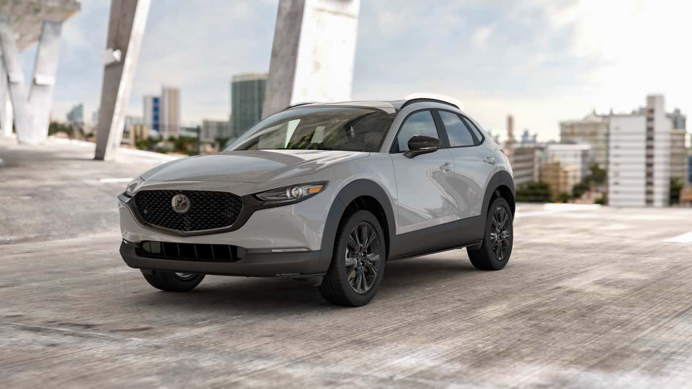 2026 MAZDA CX‑30 2.5 2.5 TURBO AIRE EDITION package parked in a concrete structure with city in background