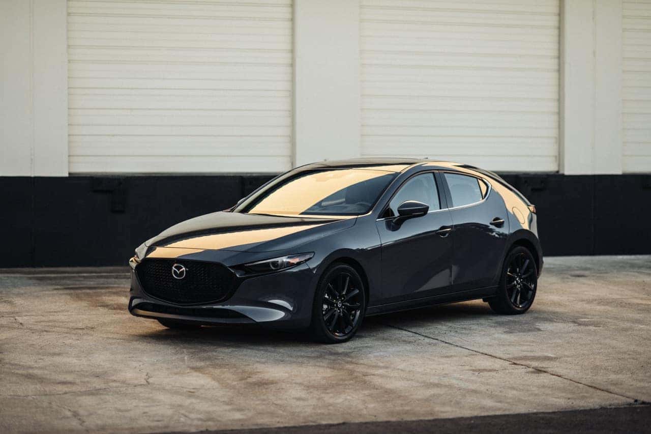 2026 Mazda3 Hatchback Body Style parked in front of a warehouse