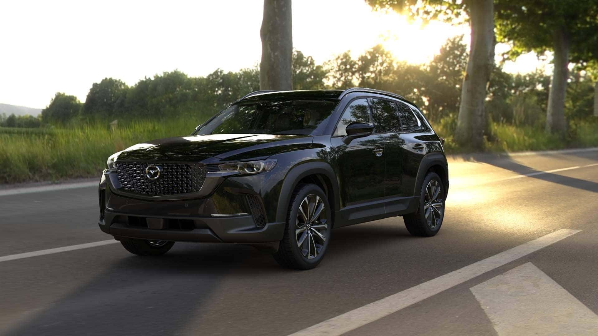 2026 Mazda CX‑50 2.5 S Premium trim level riving down a sunny countryside highway