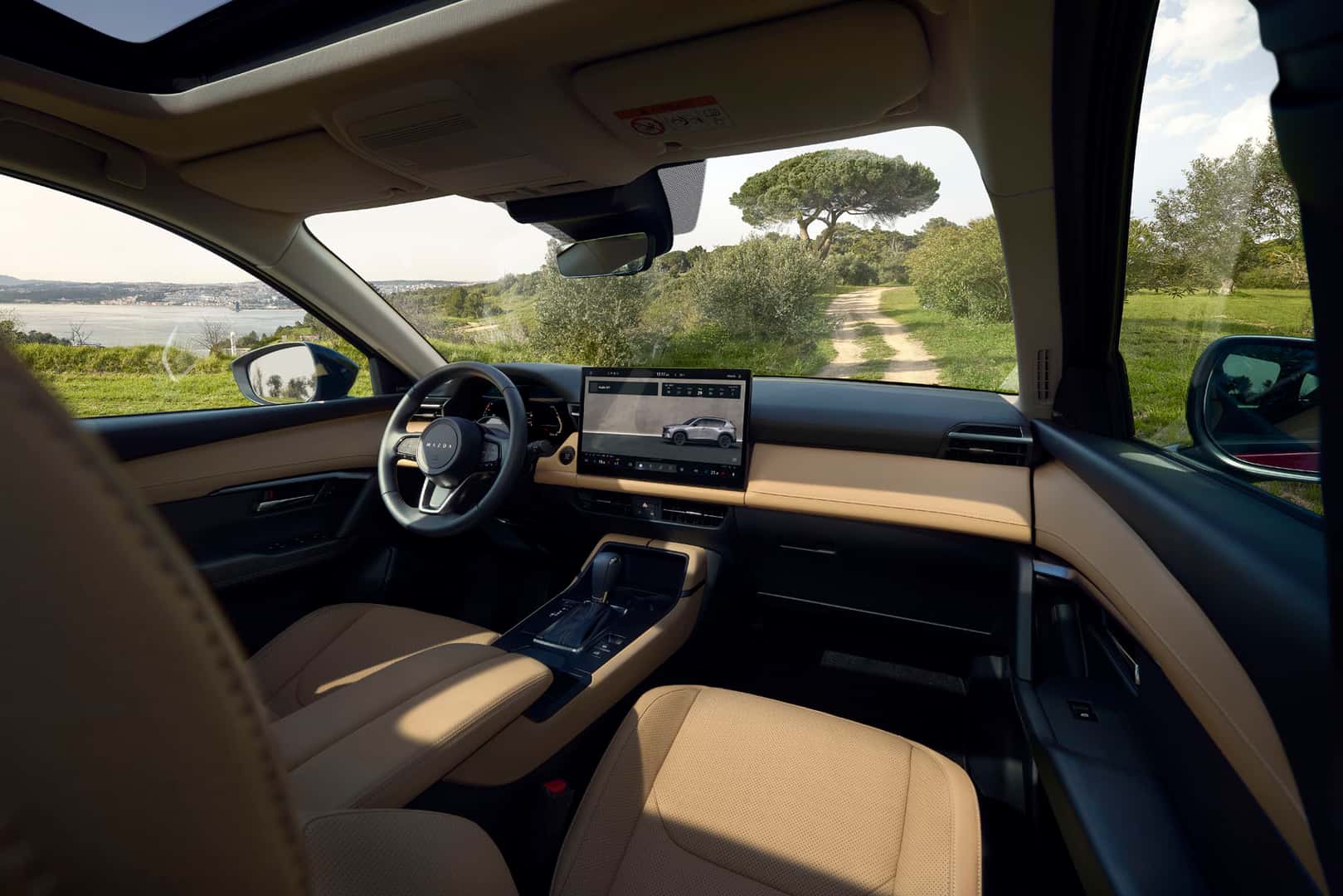 Interior view of the 2026 Mazda CX-5 with tan leather interior and a view of the ocean