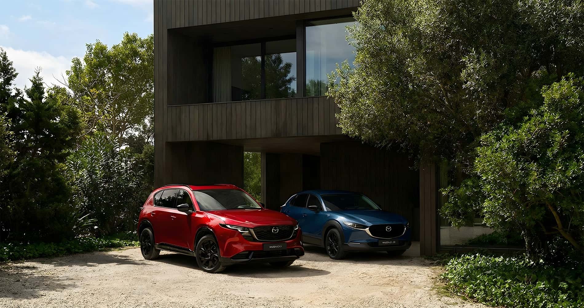 2026 MAZDA CX-5 vs CX-30 parked in front of a modern home in a rural setting