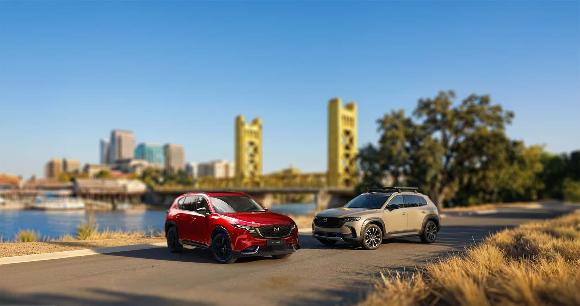 2026 MAZDA CX-5 vs CX-50 parked on the Sacramento riverfront with tower bridge in the background
