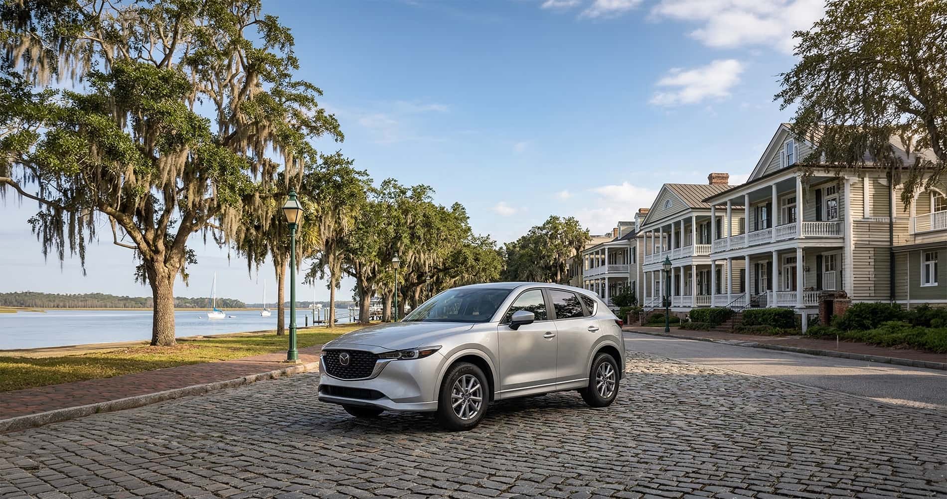 Silver Mazda CX-5 parked on cobblestone street in Bluffton with waterfront and historic homes
