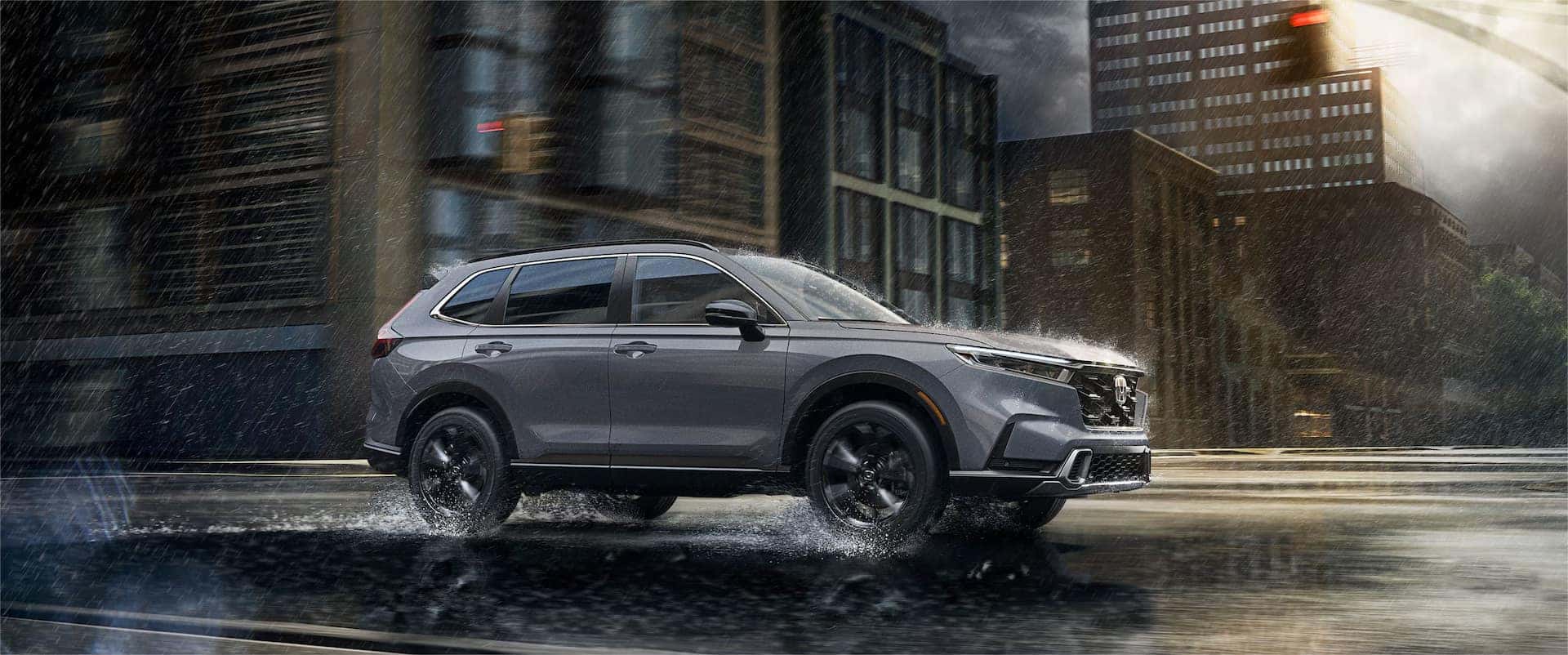2026 Honda CR-V driving through heavy rain in an urban city environment, showcasing stability and all-weather confidence on wet roads