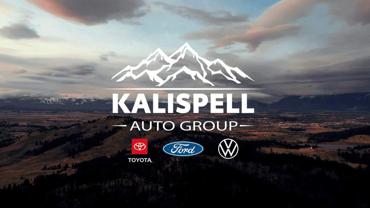 View of Kalispell MT at sunset with Kalispell Auto Group Toyota Ford and Volkswagen logo