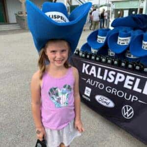 Girl standing in front of the Kalispell Auto Group tent at the KAG PBR Rodeo