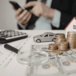 Car financing concept with calculator, cash, coins, and model car showing credit score and auto loan planning