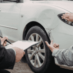 Two people inspecting a vehicle with damage