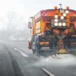 Shutterstock image of a vehicle applying road salt to a highway