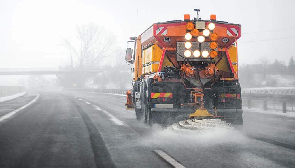 Shutterstock image of a vehicle applying road salt to a highway