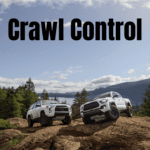 a white 4Runner and white Tacoma sitting on top of a rocky mountain peak