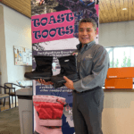 Salesman holding a pair of winter boots