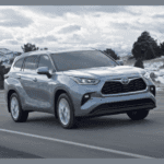 2024 New Toyota Highlander driving down a road in winter
