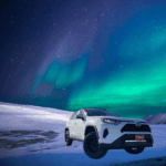 white Toyota Rav4 under a sky of northern lights