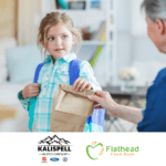 a little girl receiving food from the backpack program