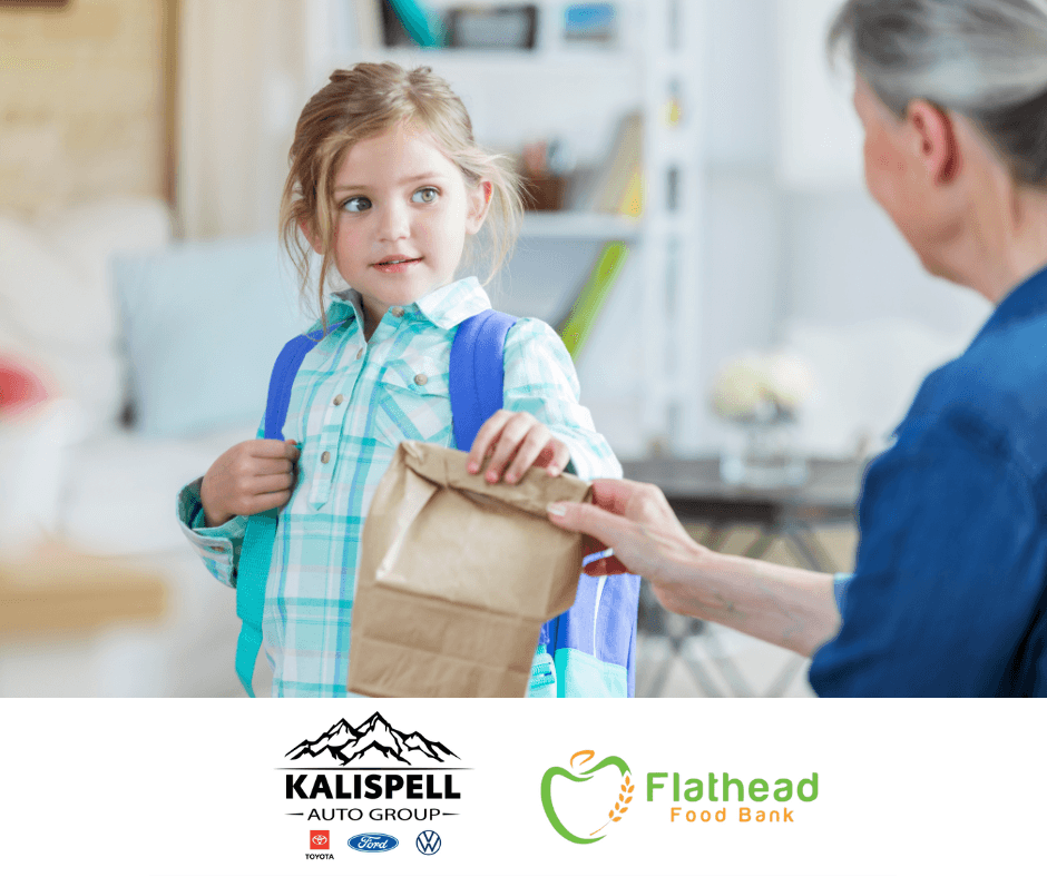 a little girl receiving food from the backpack program