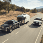 Two Toyota Tundra's on a backroad, one is pulling a camper.