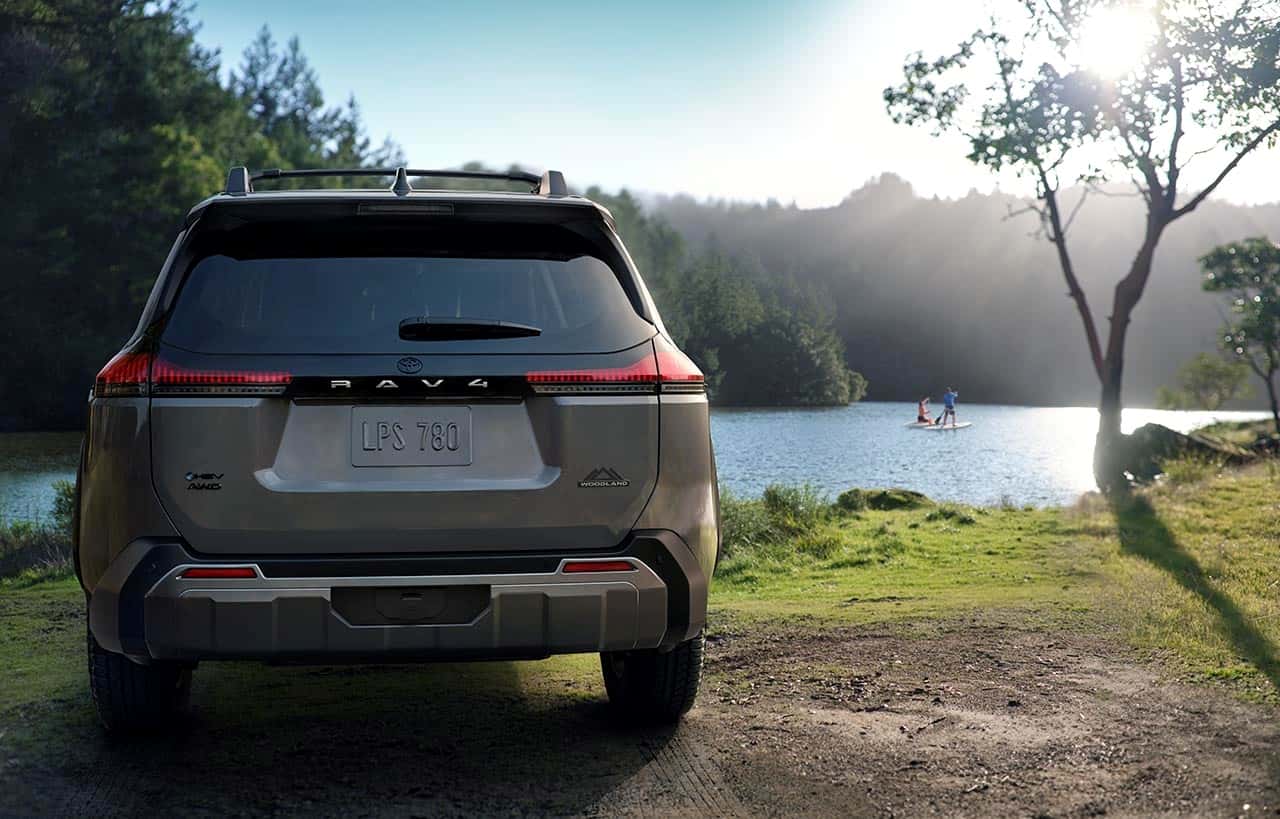 2026 Toyota Rav4 on the shore of a lake on a sunny day