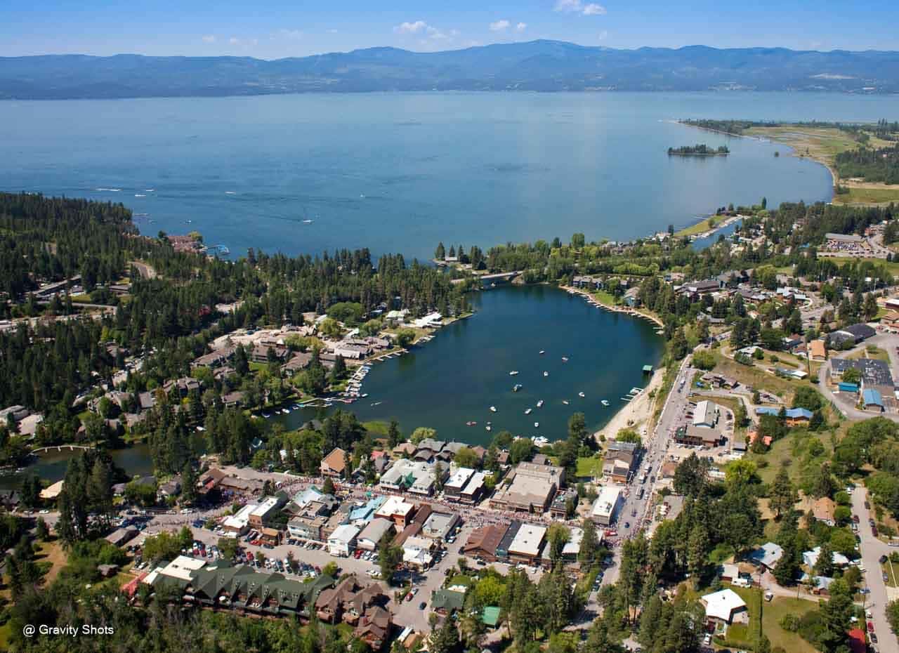 Ariel shot of Bigfork along the shore of Flathead lake with the Salish mountain range looming in the background.