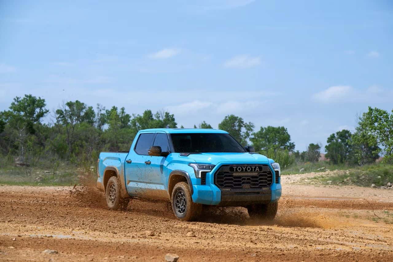 2026 Toyota Tundra TRD Pro in Wave Maker blue driving off-road on a dirt trail.