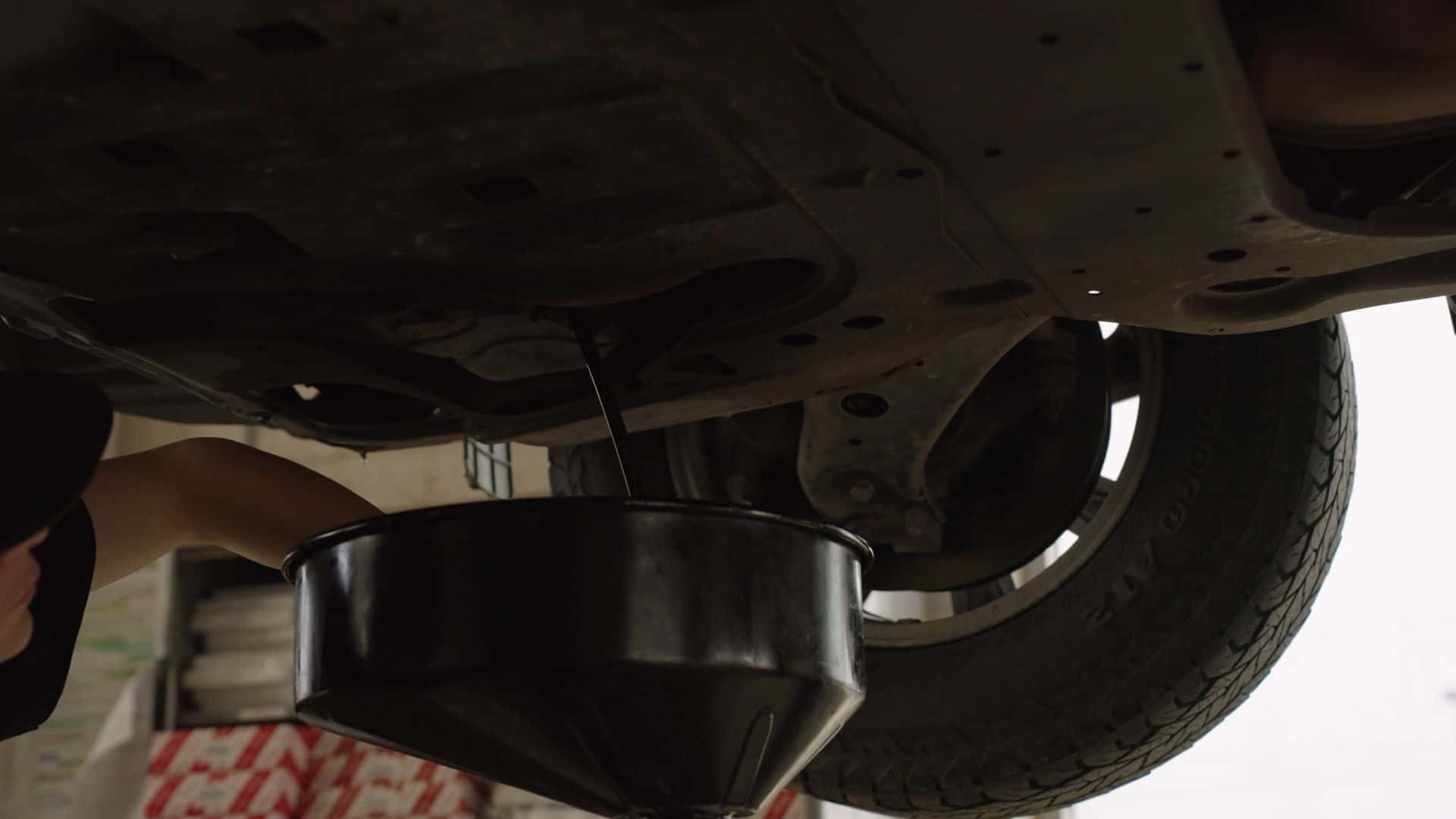 Toyota Certified technican changing out the oil in a vehicle at Kalispell Toyota