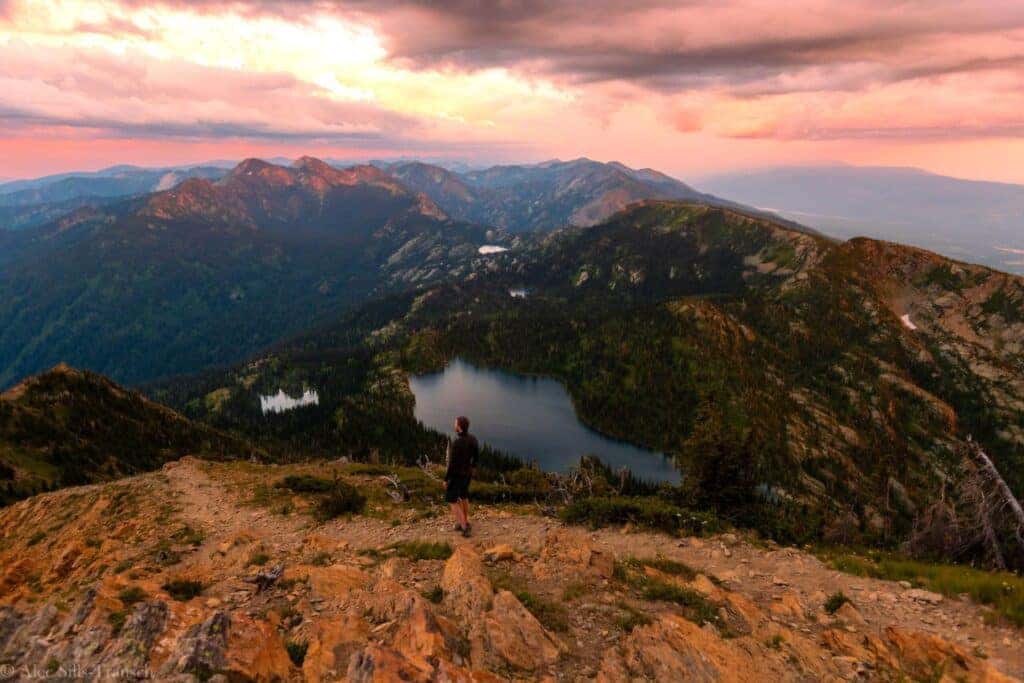 Hiker walking at the top of Mount Aeneas during sunrise, overlooking the Jewel basin