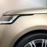 Front half of a tan 2025 Land Rover Sport at a repair shop
