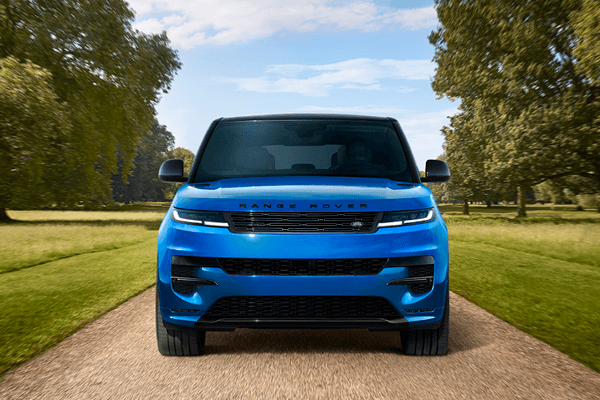 Blue Range Rover Sport driving on a dirt road