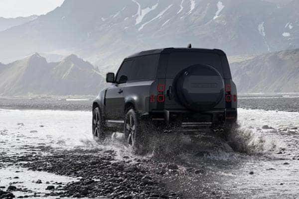 land rover defender driving on wet road