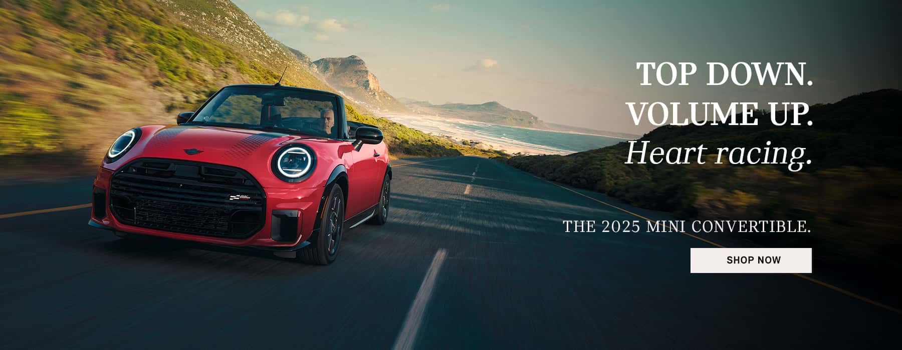 Red MINI JCW Convertible driving through mountains.