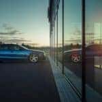 Mitsubishi car parked outside looking into the dealership and seeing its reflection