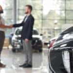 couple-making-deal-with-car-dealer