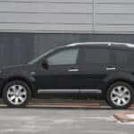Side view of a Black Mitsubishi that has 3rd row seating