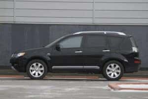 Side view of a Black Mitsubishi that has 3rd row seating