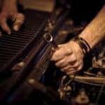 A mechanic using a wrench to work on an engine