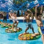 Kids walking a rope course over water at Coconut Cover Water Park