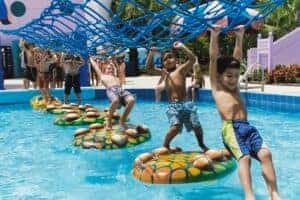Kids walking a rope course over water at Coconut Cover Water Park