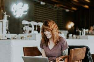 Woman sitting at a coffee shop excited about the offer she got back on her vehicle.