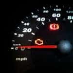 The dashboard and speedometer of a car with the check engine light on