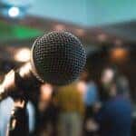 A microphone on a stage in front of people waiting to listen
