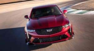 Front view of a red 2022 Cadillac CT4-V Blackwing rounding a corner after leaving a Cadillac dealer near you